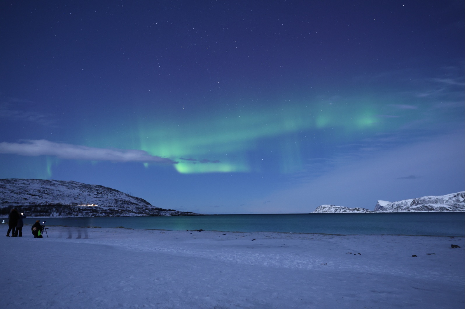 Northern lights over snowy beach in Norway